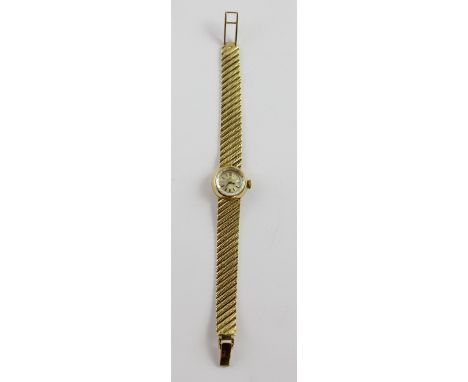 Omega; an 18ct gold ladies wristwatch the dial set with baton numerals, on textured gold strap, approx 29.5g.