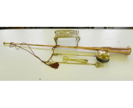 AN ORNATE CAST BRASS FOOTMAN, A BRASS TASTING FORK, CHESTNUT ROASTER, COAL TONGS AND POST HORN