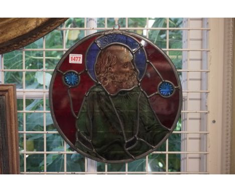 An old stained and leaded glass circular panel of a saint, 32.5cm diameter, (cracked through face).&nbsp; 