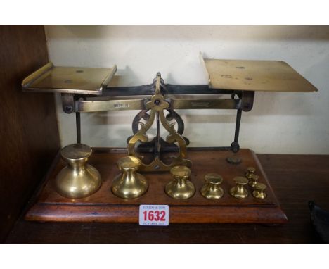 A good set of brass and mahogany postage scales, by John Heath, with eight weights, 30.4cm wide.&nbsp; 