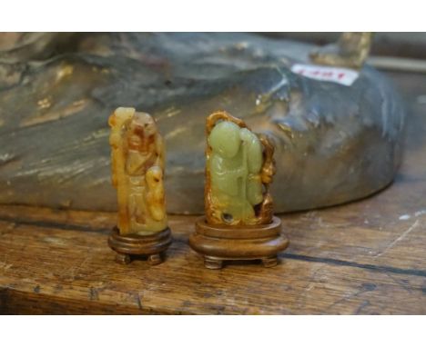 A Chinese carved green and brown jade figure of a boy, 5cm high; together with another similar figure, 5.3cm high, each on fi