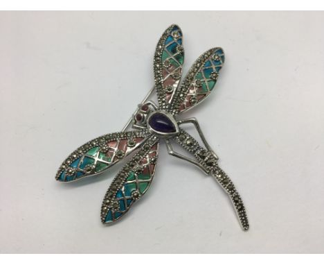 A silver dragonfly brooch set with large cabochon amethyst, ruby eyes and marcasites and inlaid with enamel