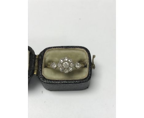 A Edwardian style diamond cluster ring with worn gold band .