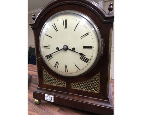 A Georgian mahogany bracket clock the painted dial with Roman numerals on gilt circular feet with bracket.