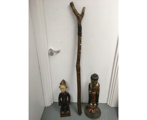 A tribal chanting stick and two carved wood figures