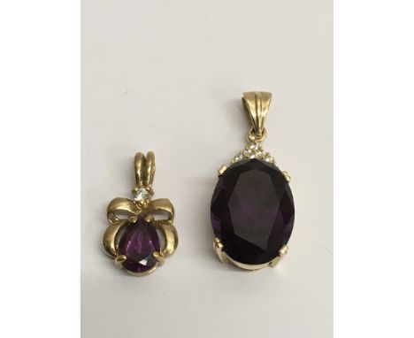 Two gold pendant drop, one 14ct, both set with amethyst type stones flanked by white chips