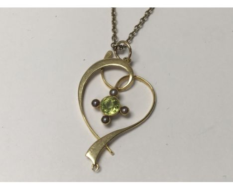 A 15carat Gold pendent set with seed pearl and Green Peridot. With attached silver chain.