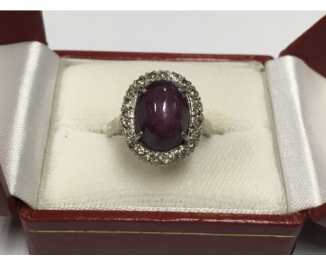 An unmarked white metal star ruby and diamond ring.