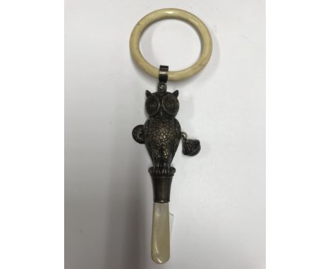 A novelty hallmarked silver teething rattle with mother of pearl handle.