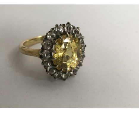 An 18ct gold ring set with a citrine in diamond surround.Approx K