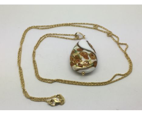 An enamel and glass pendant on a long chain.