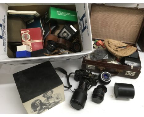 A box of cameras and accessories including a Polaroid 'Super Swinger' and a Canon SLR