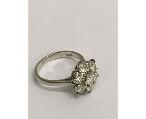 An 18ct white gold diamond cluster ring, brilliant cut stones with slight inclusions, approx size M