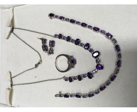 A 14ct white gold jewellery suite set with diamonds, amethyst and tanzanite comprising necklace, bracelet, ring and earrings.