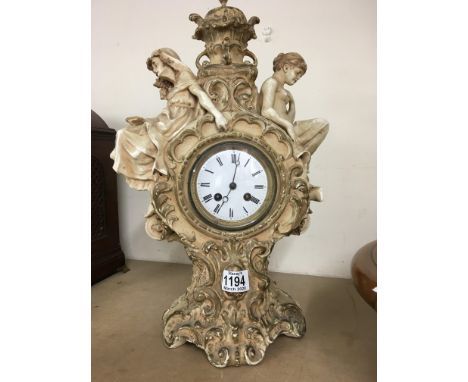 A Victorian pottery clock case young and old with classical influence the enamel dial with Roman numerals . 46 cm
