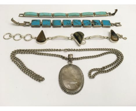 A silver and cabouchon clear stone pendant necklace and three silver hardstone bracelets