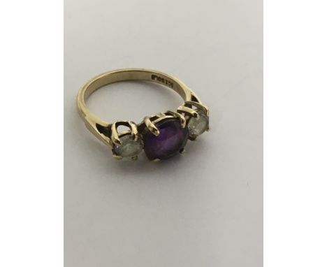 A 9ct gold ring set with an amethyst flanked by white stones.Approx O.