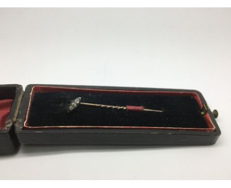 A small stick pin set with three diamonds.