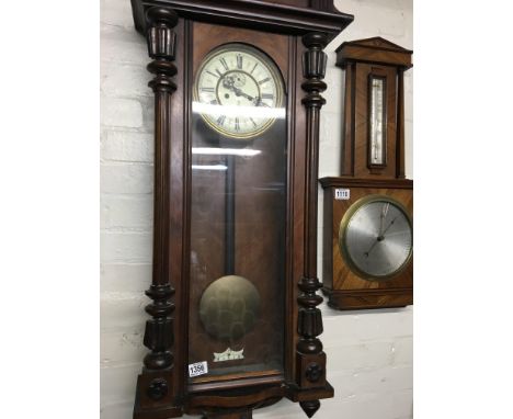 A walnut Vienna double weight wall clock the enamel dial with Roman numerals and visible pendulum.