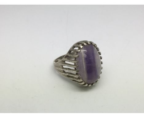 A silver ring set with a purple stone, approx size M.