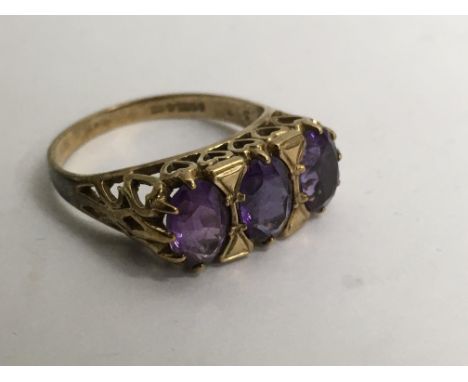 A 9ct gold ring set with three amethysts.Approx P