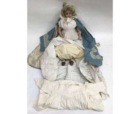 A good late Victorian wax composite body doll, having blue glass eyes and real hair, in original dress including brocade cloa