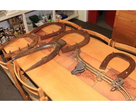 Four horseshoe shaped hunting crop racks, an antique yoke and a pair of brass horse hames.
