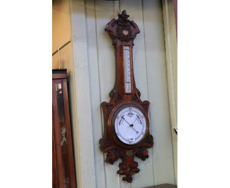 Carved oak barometer with enamelled dial.