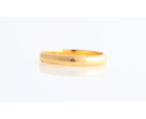 A wedding band, stamped 22ct, ring size K.