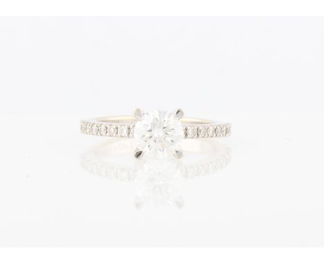 A diamond ring, set with a principal round brilliant cut diamond, measuring approx. 1.02ct, flanked to either side with eight