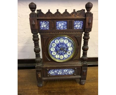 An L. Marti et Cie oak cased clock with raised gallery top, turned and fluted columns and blue and white enamelled face.
