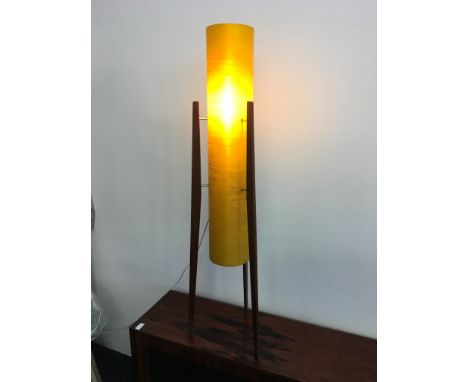 An orange cylinder mid century floor standing light fitting standing on three legs.