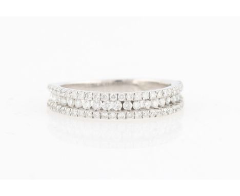 A diamond half eternity ring, set with three rows of round brilliant cut diamonds, unmarked white metal, ring size K.
