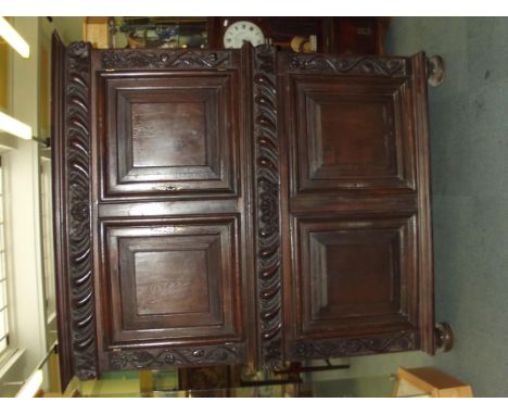 Georgian oak two section livery cupboard, carved boarders with scrolls, shells, whorling and fruiting vines, cast iron C shap