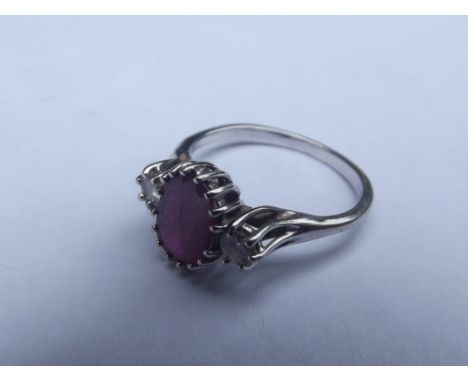 White metal (tested for high carat) ring with central ruby flanked by two shoulder diamonds, size K
