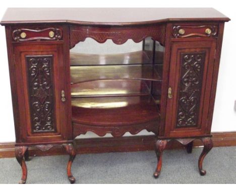 Edwardian bow fronted sideboard, central shelves with mirrored back flanked by two cupboards and two drawers, raised on cabro