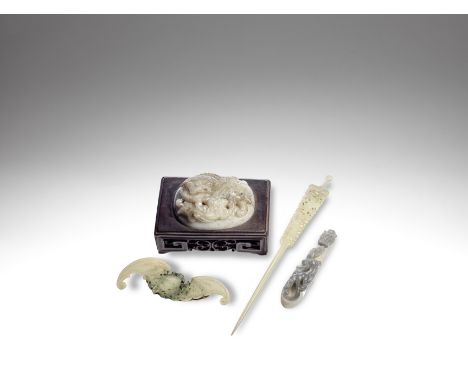 A group of four jade carvings17th/18th century and laterComprising: a Buddhist lion and cub oval plaque, the stone of pale gr