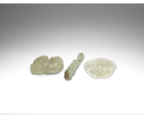 A group of three jade carvingsQing DynastyComprising: a pale green jade openwork butterfly plaque; a 'horse and monkey' buckl