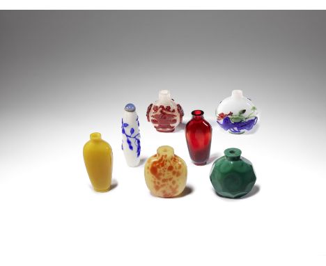 Seven glass snuff bottlesQing DynastyComprising: a three-colour overlay glass bottle decorated  with lotus; a faceted green g