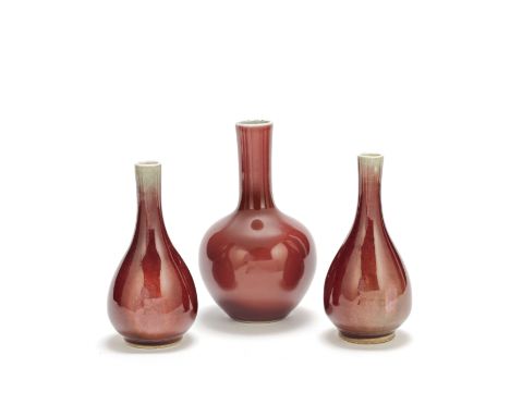 Three copper red glazed vases19th centuryComprising: two pear-shaped bottle vases with slender tapering necks; and a larger b