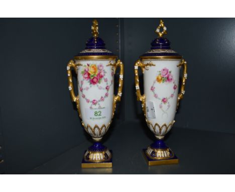 A pair of two hand decorated Royal Worcester urns hand painted by E.Phillips, both show signs of professional restoration
22c