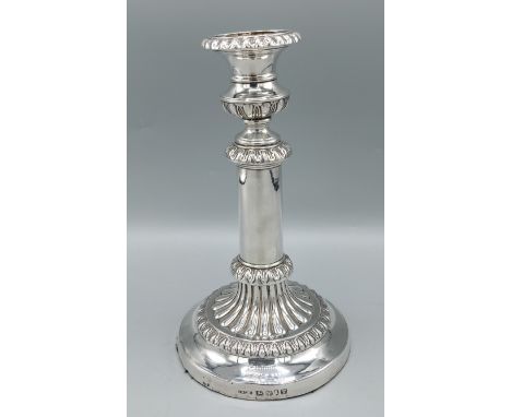 A George III silver candlestick with embossed decoration, Sheffield 1816, marker John &amp; Thomas Settle, 21cms tall 