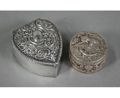 An Edwardian circular silver small box, the cover finely embossed and chased with a cat hunting a lizard above lion-mask and 