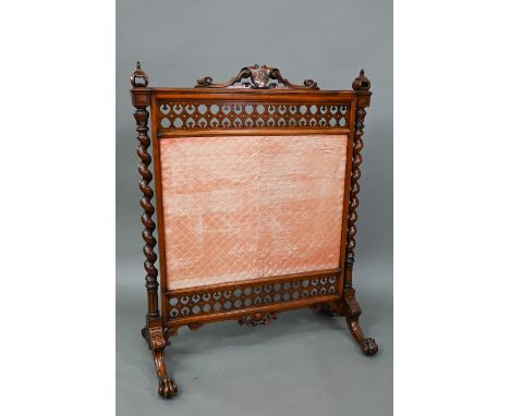 A Victorian mahogany framed fire screen with polychrome armorial device to the crest rail, over a fabric panel, raised on mou