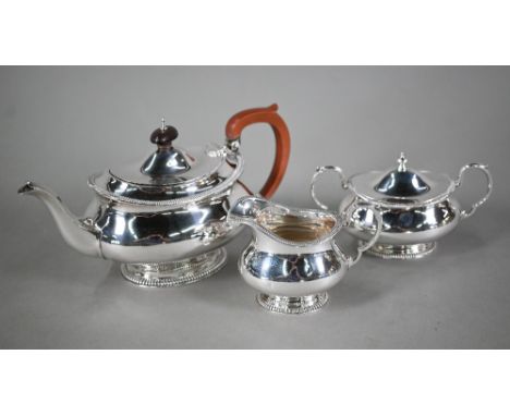 A heavy quality silver three-piece tea service of oval pot-bellied form with moulded rims and raised pedestal bases, c/w cove
