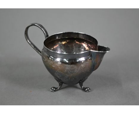 Frank Finley Clarkson (Northallerton), an Arts and Crafts style cream jug of cauldron form, with scroll handle and three hoof