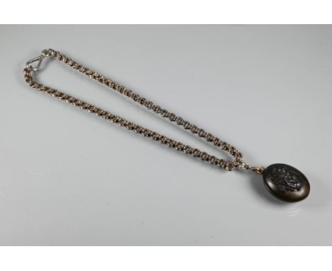 A Victorian Whitby jet oval locket with cameo carved in high relief to front, and opening to reveal locket, 3.5 cm high, on d