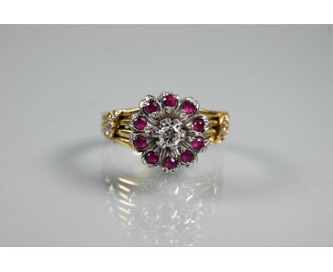 A diamond and ruby cluster ring, the cluster in the form of petals set with central diamond surrounded by ten rubies, on 18 c