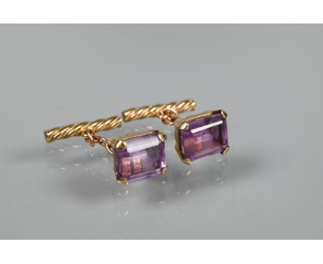 A pair of chain-linked cufflinks set with rectangular amethyst with twisted baton backs, yellow metal set, unmarked and untes