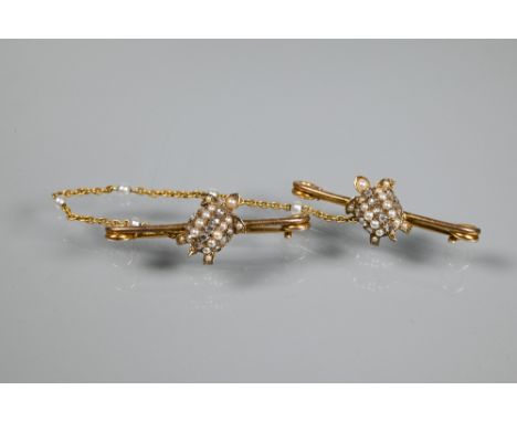 A pair of yellow gold bar brooches, each mounted with diamond and seed pearl set turtles, pearl set chain linking the two, ea